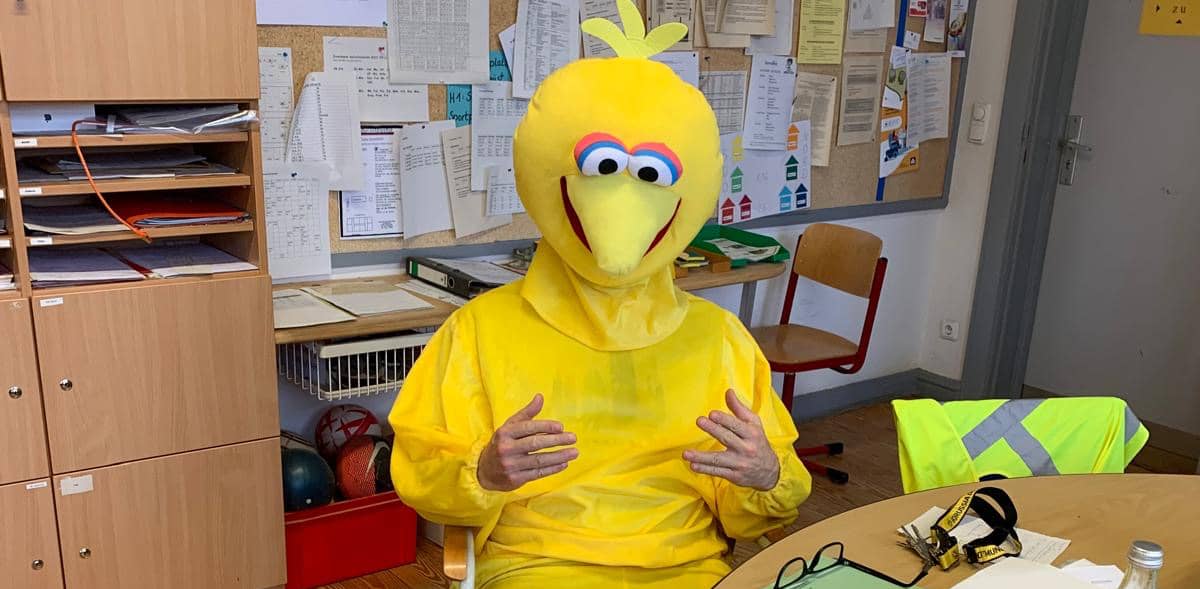 Ein Lehrer im Bibo-Kostüm im Lehrerzimmer