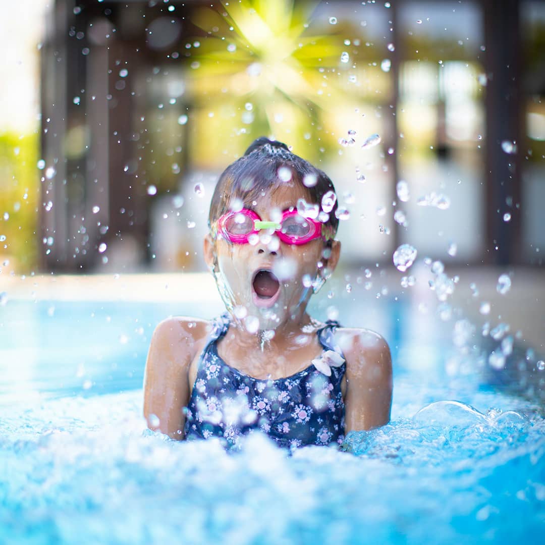 Ein Mädchen mit Schwimmbrille in einem Becken